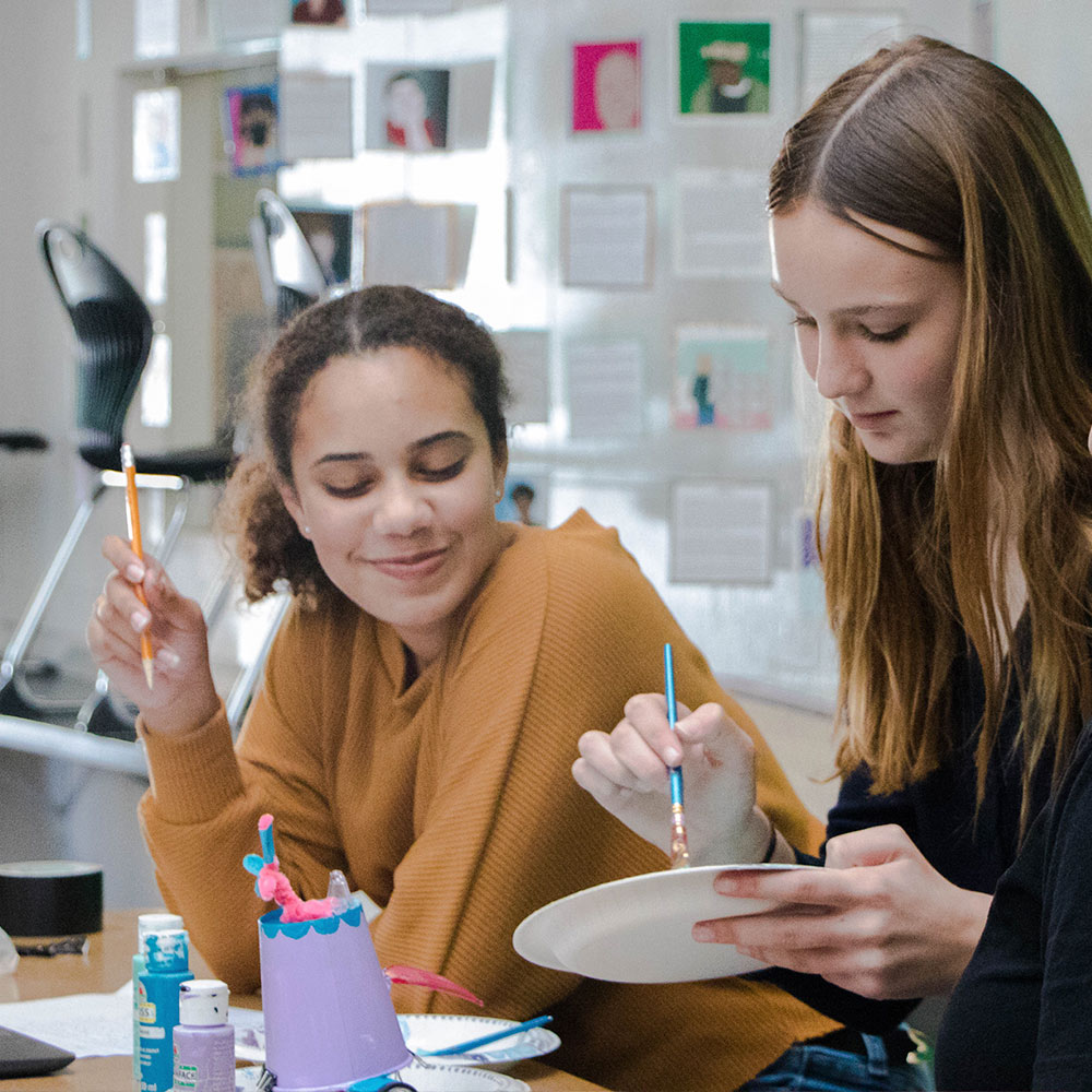 Two students painting in an art-based project