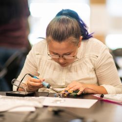 A student soldering wires for a project