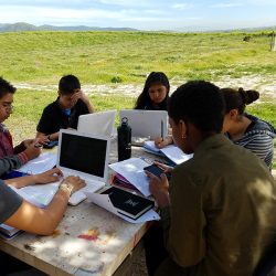 Middle School-aged teens collaborate together in an outside classroom setting